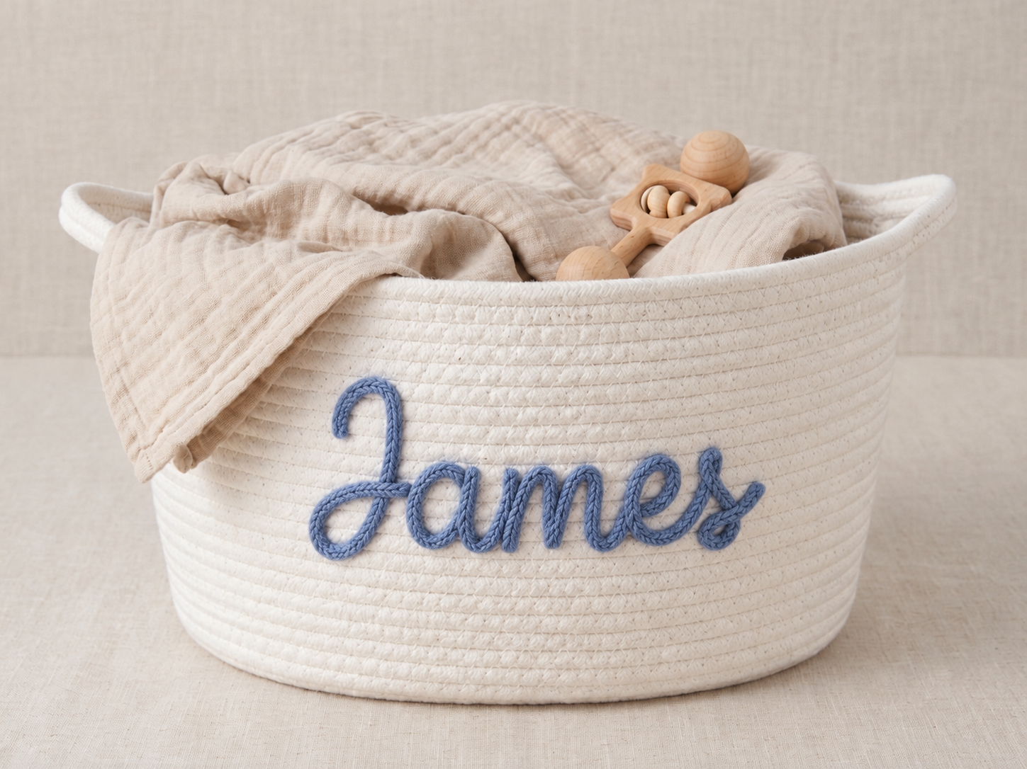 Illustrative cream rope basket with James in blue embroidery